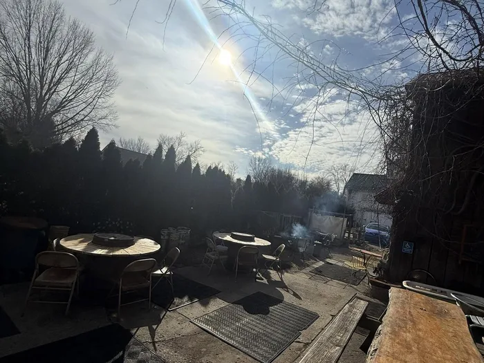 The back patio at Taco Dan's with picnic tables and fire-pit tables
