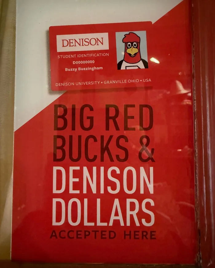A window sign that reads Big Red Bucks and Denison Dollars accepted here